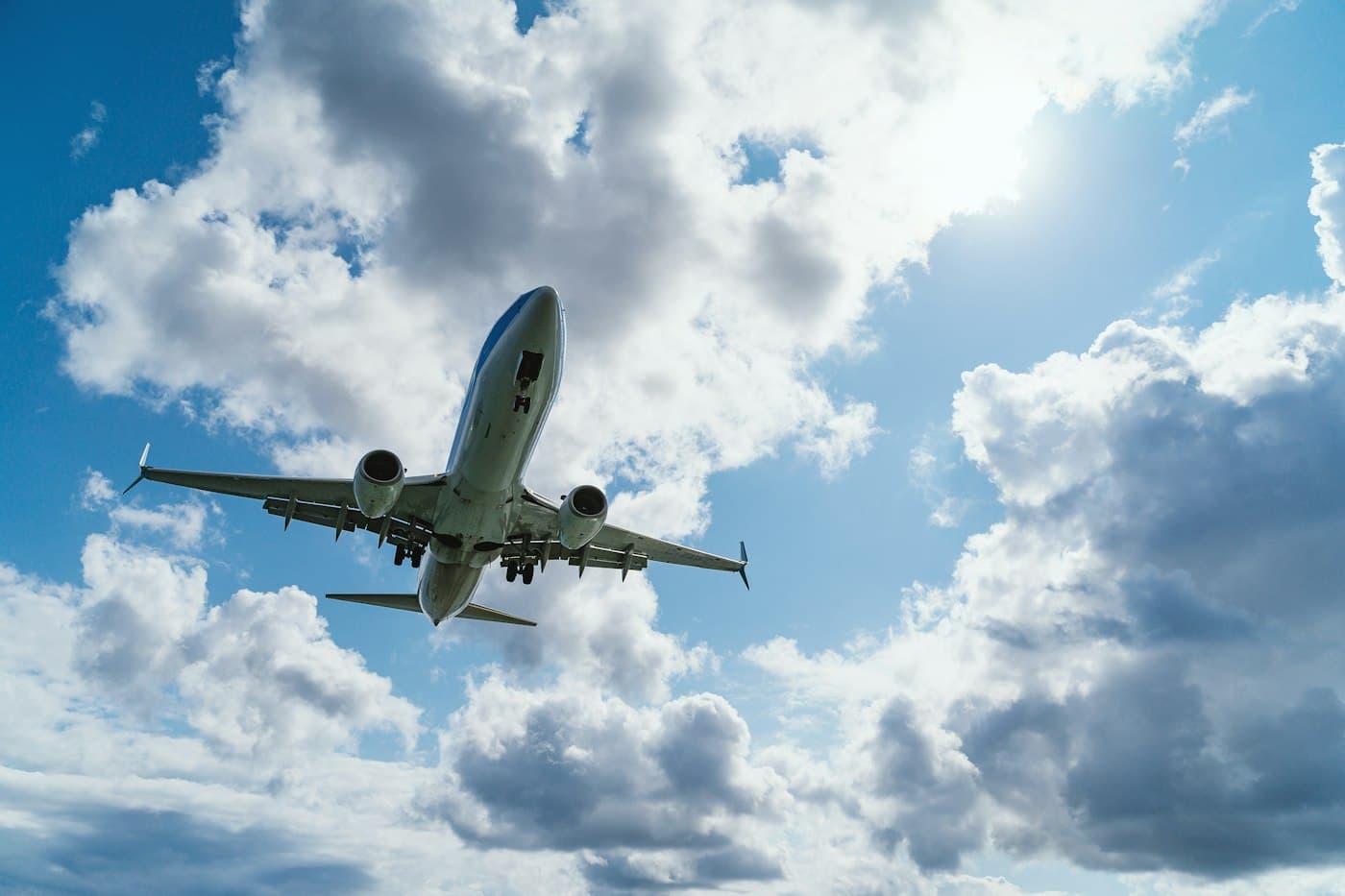 A cargo aircraft climbing through a cloudy sky